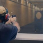 A man fires at a target in a gun range